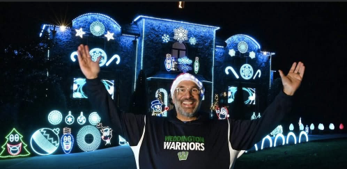 Neil in front of the illuminated High Flying Lights house